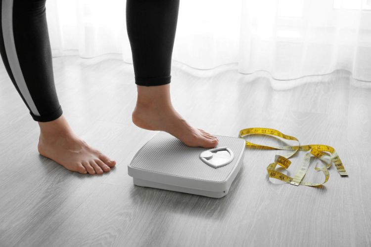 feet stepping on a set of scales and a tape measure used on a blog about glp-1 agonists