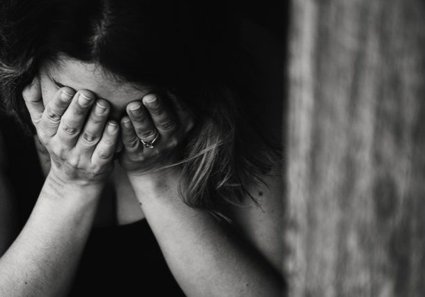 woman with head in hands | suffering from fluctuating female hormone levels | perpetual wellbeing
