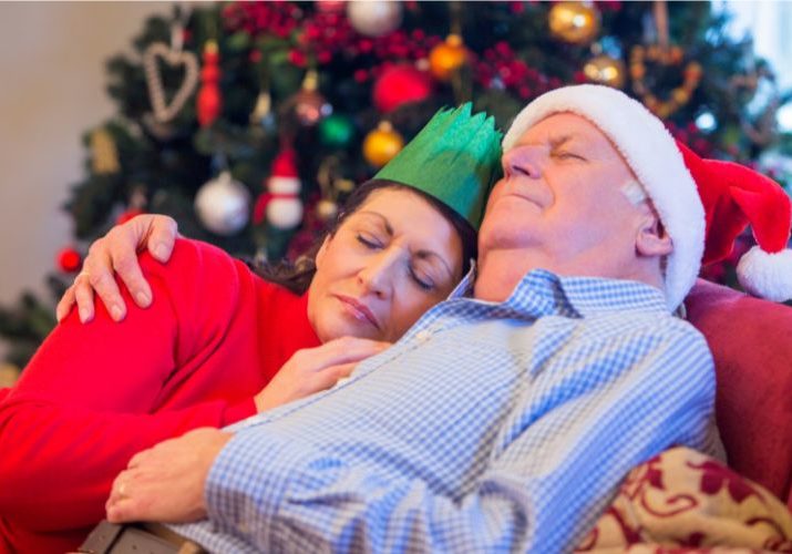 couple sleeping on sofa after christmas over indulgence