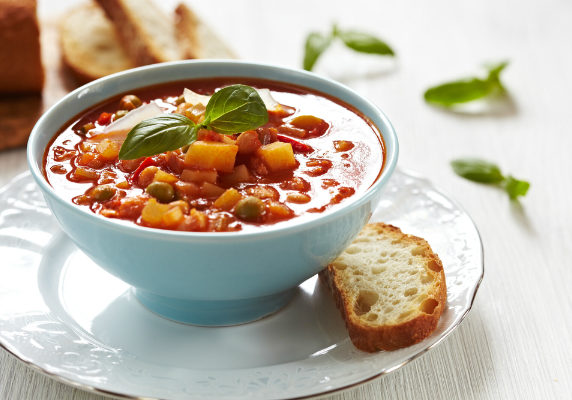 bowl of minestrone soup with a slice of bread